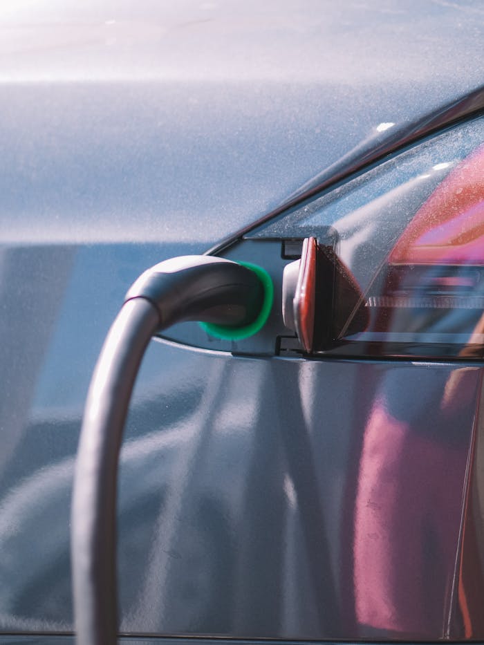 about-us Close-up of an electric car plugged into a charging station, showcasing modern technology.